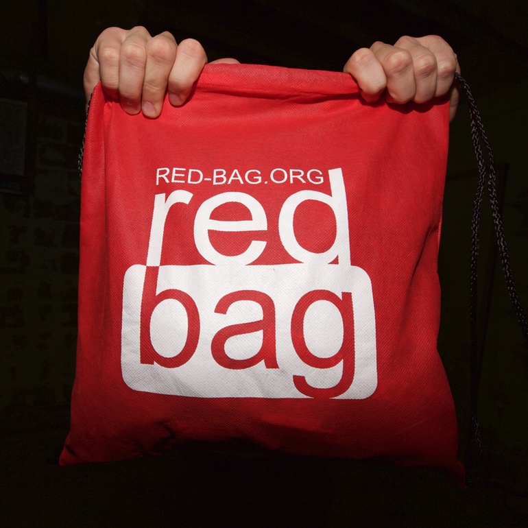 A Red Bag held up against a dark background